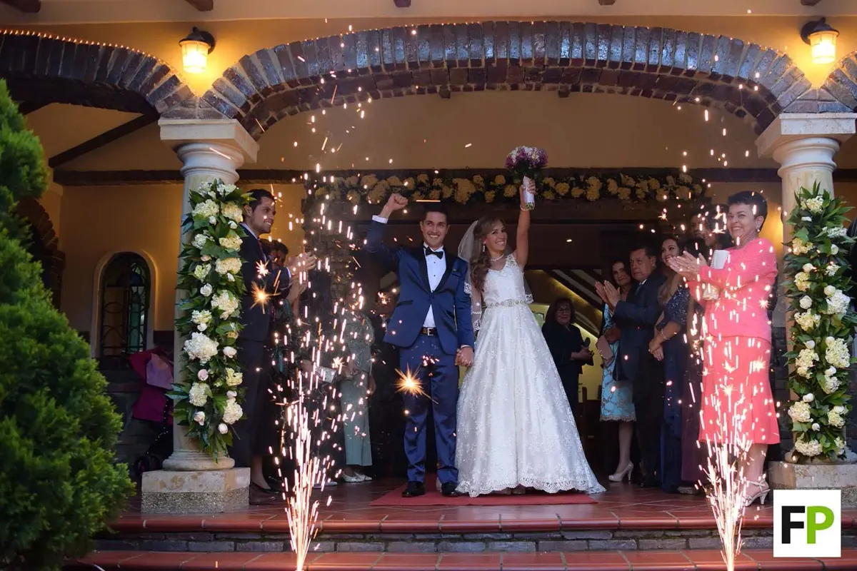 Pareja de recién casados celebrando con pirotecnia en su boda