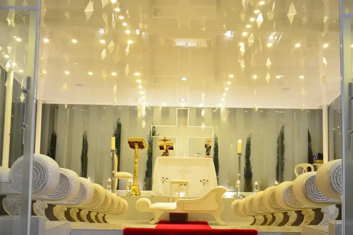 Altar de una capilla con cruz blanca decorado para una boda