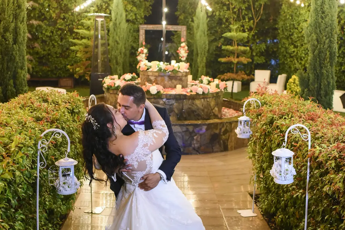Pareja de novios frente a un altar decorado con flores y luces