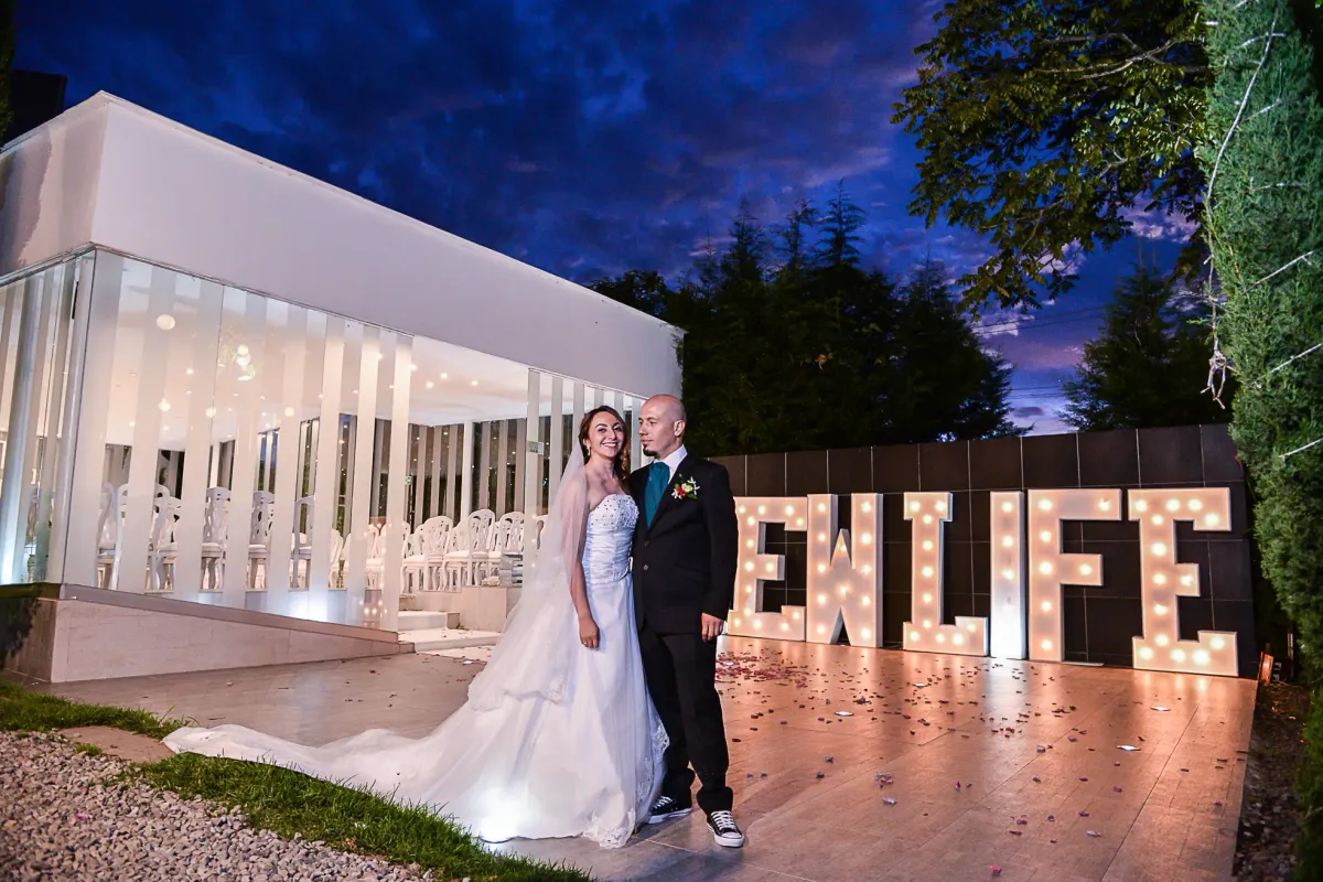 Pareja de recién casados frente a una capilla de cristal en su boda civil