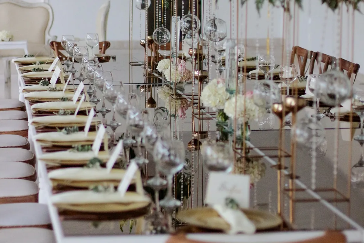 Montaje de mesa elegante con espejo y flores para una boda