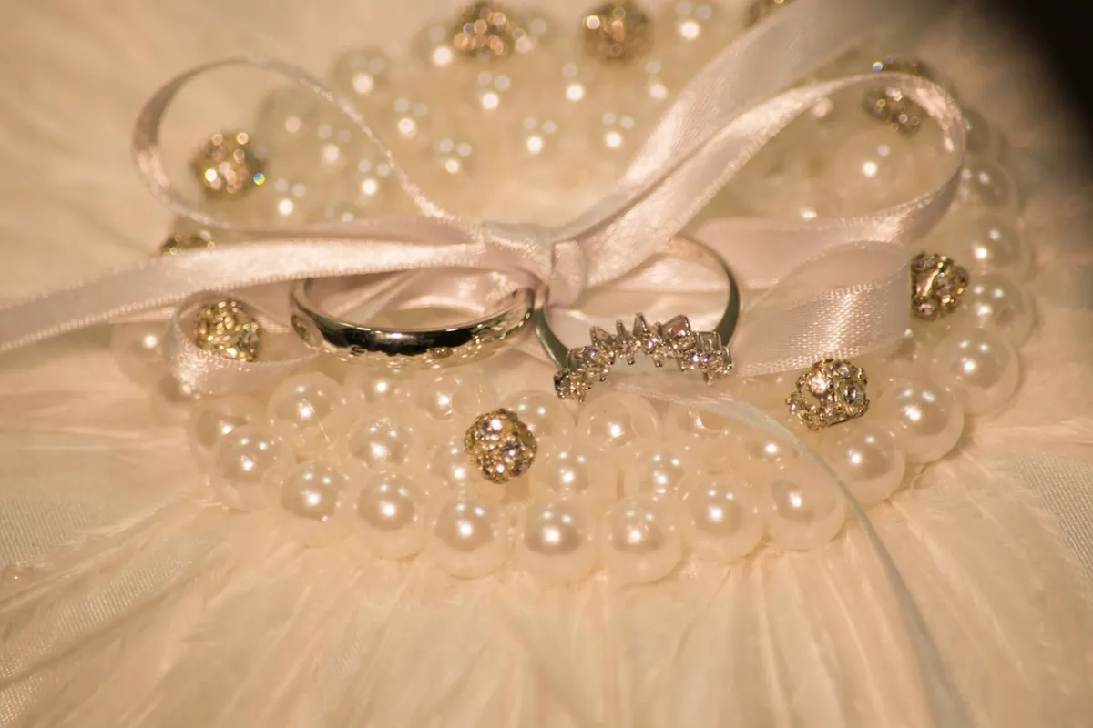 Argollas de boda sobre un cojín de perlas