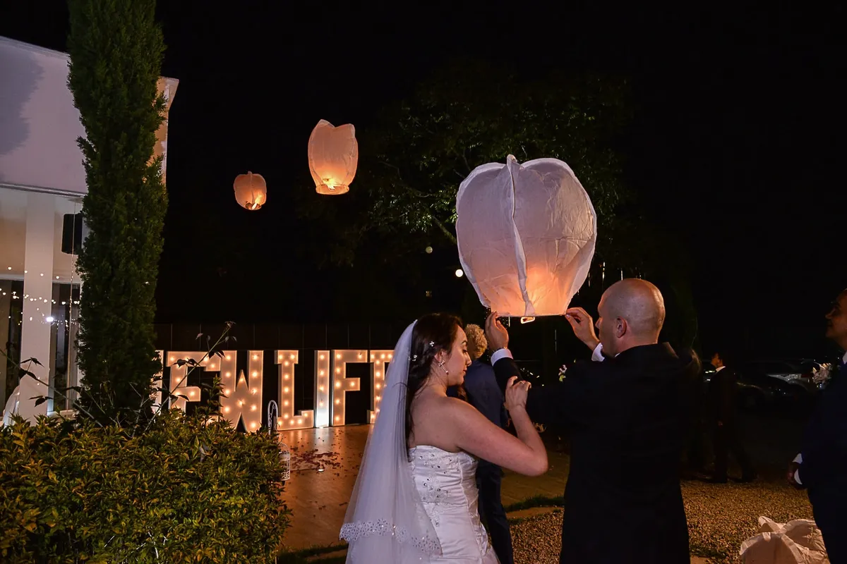 Pareja de recién casados soltando un farol de deseos de noche