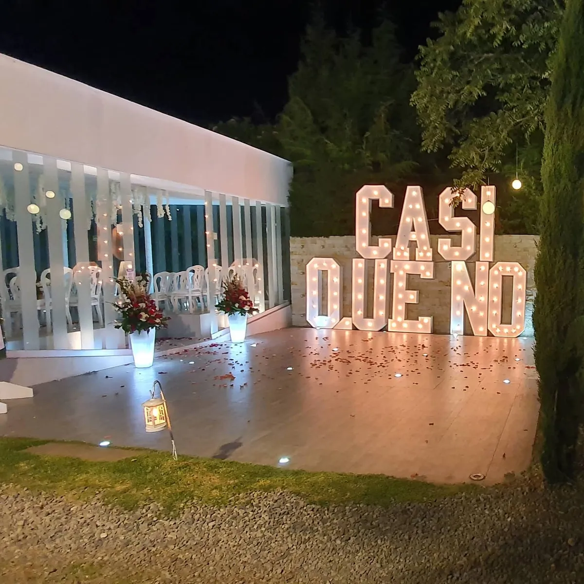 Letras luminosas y decoración nocturna en un jardín de eventos