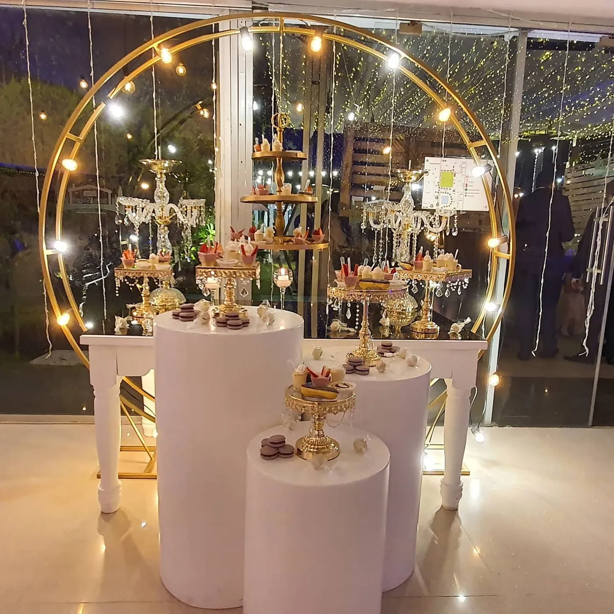 Mesa de dulces y bebidas decorada con luces para una fiesta de quince