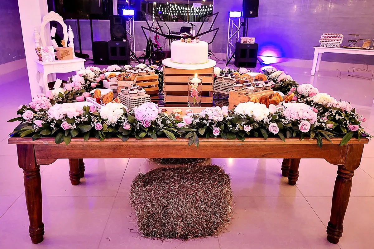 Mesa de postres con pastel de boda y flores para una fiesta