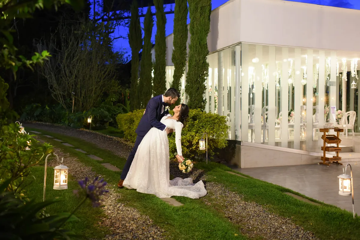 Pareja de recién casados frente a una capilla iluminada en Bogotá